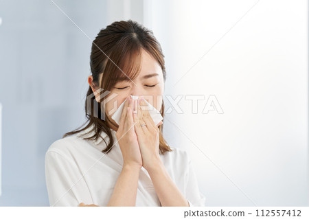 一名婦女因鼻炎擤鼻涕 一名婦女因鼻炎擤鼻涕 112557412