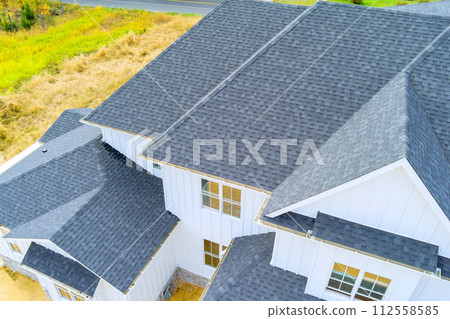 Roof of newly constructed house is covered with asphalt shingles 112558585