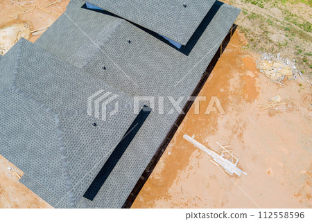 On roof top of newly constructed house, asphalt shingles are used as roofing material On roof top of newly constructed house, asphalt shingles are used as roofing material 112558596