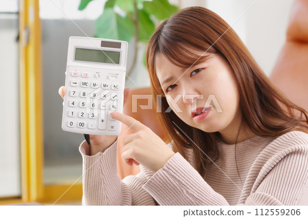 一個拿著計算機、表情困惑的女人 112559206