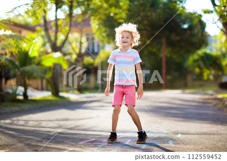 Kids play hopscotch in summer park. Outdoor game. Kids play hopscotch in summer park. Outdoor game. 112559452