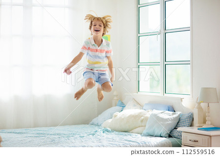 Child playing in bed. Kids room. Boy at home. 112559516