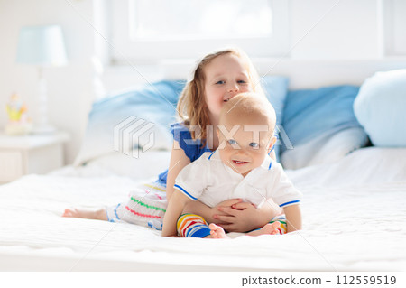 Kids playing on parents bed 112559519