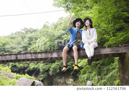 Young couple taking a commemorative photo on the bridge 112561706