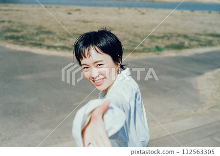 Stylish woman with short cut smiling outside 112563305