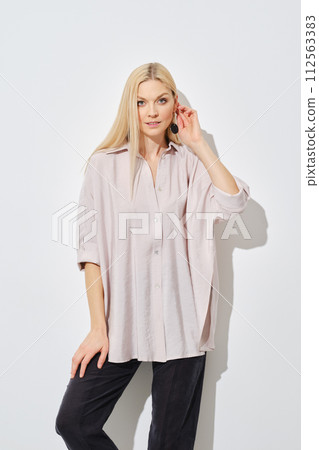 Cute woman with her shirt out is leaning against the wall 112563383