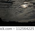The moon seen through the gaps in the clouds 112564225