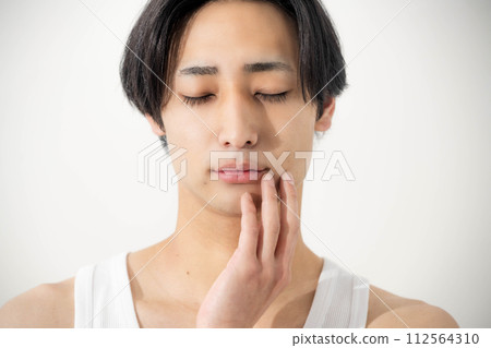 young man touching his face 112564310