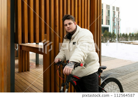 A handsome young guy stopped to rest while cycling 112564587