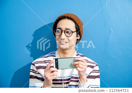 藍色背景和戴眼鏡的年輕人 112564721