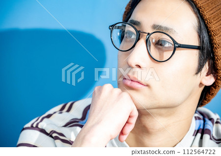 藍色背景和戴眼鏡的年輕人 112564722