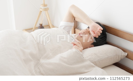 一名男子睡覺時用溫度計測量體溫 112565273