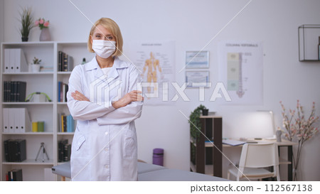 Portrait of a pleasant female therapist in a protective face mask ready to provide health care 112567138