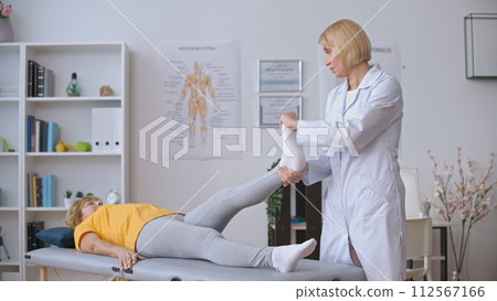 A doctor evaluates a patient suffering from joint inflammation, providing arthritis treatment A doctor evaluates a patient suffering from joint inflammation, providing arthritis treatment 112567166