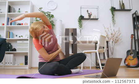 A female fitness trainer holds an online lesson, training a client via video call A female fitness trainer holds an online lesson, training a client via video call 112567371