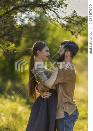young couple hugging in nature young couple hugging in nature 112567609