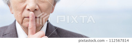 An elderly Asian man putting his index finger on his lips 112567814