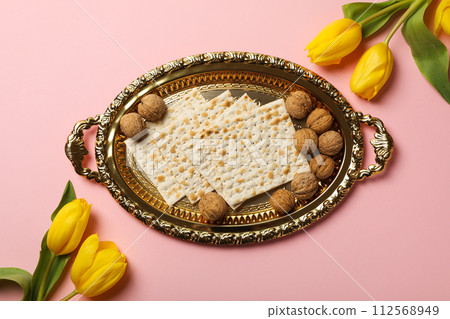 Matzo, nuts and flowers on pink background, top view Matzo, nuts and flowers on pink background, top view 112568949