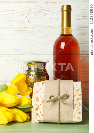 Matzo, bottle of wine, cup and flowers on wooden background Matzo, bottle of wine, cup and flowers on wooden background 112568950