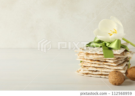 Matzo, nuts and flower on light background, space for text Matzo, nuts and flower on light background, space for text 112568959