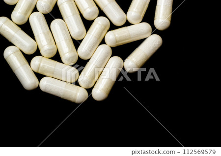 White capsules, pills on a black background with place for text. Medicine, healthcare concept. Range of pharmaceutical drugs 112569579