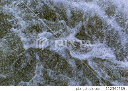 Close up detail of fierce white water river rapids from a clean deep green colored river forming a textured background Close up detail of fierce white water river rapids from a clean deep green colored river forming a textured background 112569589