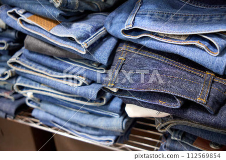 大量牛仔褲堆放在架子上 大量牛仔褲堆放在架子上 112569854