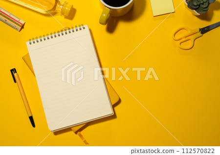 Blank spiral notepad, water bottle and stationery on yellow background with copy space Blank spiral notepad, water bottle and stationery on yellow background with copy space 112570822