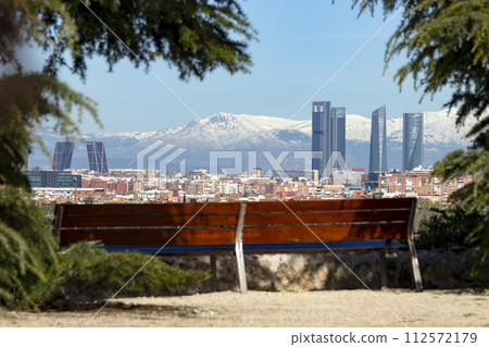 Sierra de Guadarrama. Mountain system seen from the city of Madrid with the recently snow-covered mountains covering the entire top of the mountain range in a white blanket. Skyline next to mountains. 112572179