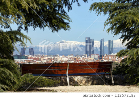 Sierra de Guadarrama. Mountain system seen from the city of Madrid with the recently snow-covered mountains covering the entire top of the mountain range in a white blanket. Skyline next to mountains. Sierra de Guadarrama. Mountain system seen from the city of Madrid with the recently snow-covered mountains covering the entire top of the mountain range in a white blanket. Skyline next to mountains. 112572182