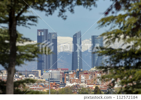 Sierra de Guadarrama. Mountain system seen from the city of Madrid with the recently snow-covered mountains covering the entire top of the mountain range in a white blanket. Skyline next to mountains. 112572184
