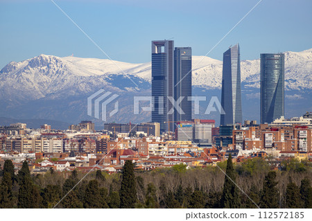 Sierra de Guadarrama. Mountain system seen from the city of Madrid with the recently snow-covered mountains covering the entire top of the mountain range in a white blanket. Skyline next to mountains. Sierra de Guadarrama. Mountain system seen from the city of Madrid with the recently snow-covered mountains covering the entire top of the mountain range in a white blanket. Skyline next to mountains. 112572185