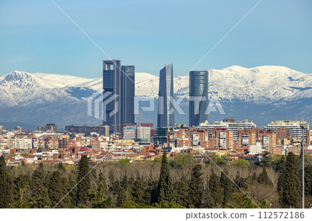Sierra de Guadarrama. Mountain system seen from the city of Madrid with the recently snow-covered mountains covering the entire top of the mountain range in a white blanket. Skyline next to mountains. 112572186
