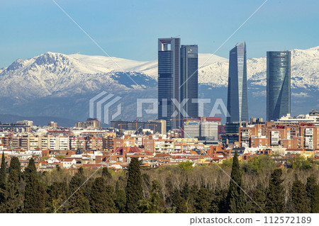 Sierra de Guadarrama. Mountain system seen from the city of Madrid with the recently snow-covered mountains covering the entire top of the mountain range in a white blanket. Skyline next to mountains. 112572189