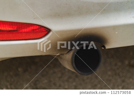 A malfunctioning engine and exhaust afterburner system show the results close up in the form of black soot over the muffler of an internal combustion vehicle. Real example of ecologic problems, solve 112573058