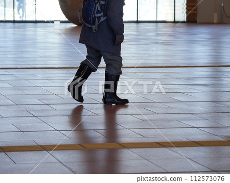 A senior man walking in the plaza of Asahikawa Station in winter 112573076