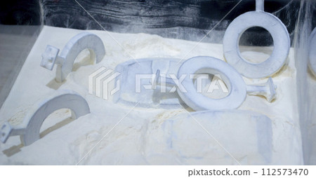 White polyamide powder and object on 3D printed from white polyamide powder close-up. Polyamide powder for creating objects on 3D printer. Additive MJF Multi Jet Fusion technologies. Thermoplastic White polyamide powder and object on 3D printed from white polyamide powder close-up. Polyamide powder for creating objects on 3D printer. Additive MJF Multi Jet Fusion technologies. Thermoplastic 112573470