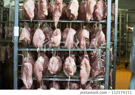 Meat factory.The fillet suspended on a rope in the drying chamber of the meat processing plant Meat factory.The fillet suspended on a rope in the drying chamber of the meat processing plant 112574151