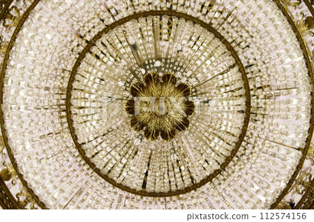 Crystal chandelier close-up. Fragment of the rich theatrical chandelier Crystal chandelier close-up. Fragment of the rich theatrical chandelier 112574156