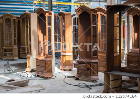Furniture manufacture from a natural tree.Furniture manufacture. Factory for the manufacture of expensive furniture. To do cabinets. Wood processing in furniture 112574164
