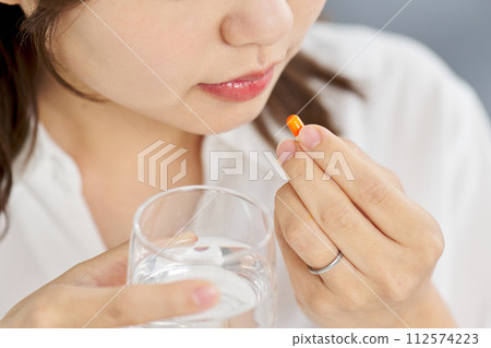 woman taking capsule medicine 112574223