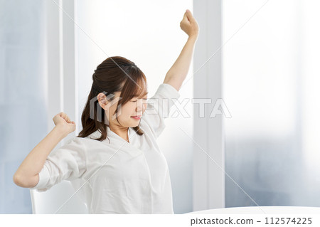 A woman stretching in a room A woman stretching in a room 112574225