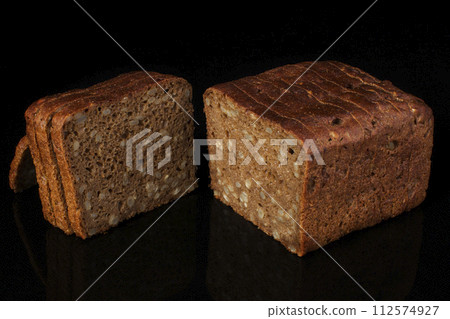 Ordinary bread with grains and sesame cut into pieces on a black background. Whole wheat bread Ordinary bread with grains and sesame cut into pieces on a black background. Whole wheat bread 112574927