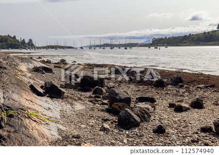 Loch Linnhe's gentle waves at Oban with distant yachts 112574940