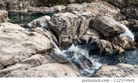 Crystalline waters cascade over rugged rocks into serene pools at the Isle of Skye's Fairy Pools Crystalline waters cascade over rugged rocks into serene pools at the Isle of Skye's Fairy Pools 112574945