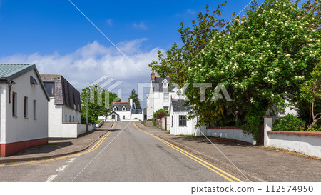 White-rendered houses of Ullapool among vibrant foliage and blossoms, beneath Scotland's blue skies White-rendered houses of Ullapool among vibrant foliage and blossoms, beneath Scotland's blue skies 112574950