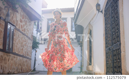 female summer travel to Antalya, Turkey. young asian woman in red dress walk through old town Kalechi , female tourist traveler discover interesting places and popular tourist attraction 112575079