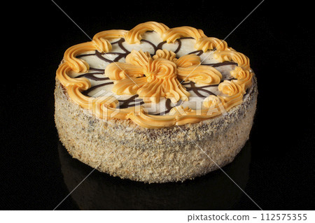 Cake decorated with chocolate mesh and butter cream on a dark background closeup 112575355