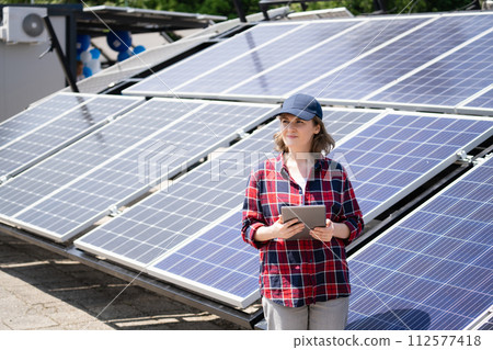 Woman with digital tablet next to solar power station Woman with digital tablet next to solar power station 112577418