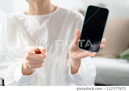 Angry woman holding a smartphone Angry woman holding a smartphone 112577675